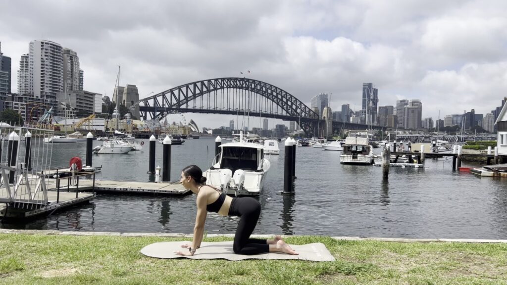 A woman doing a core-focused Pilates mat workout from home as part of her Pilates membership.