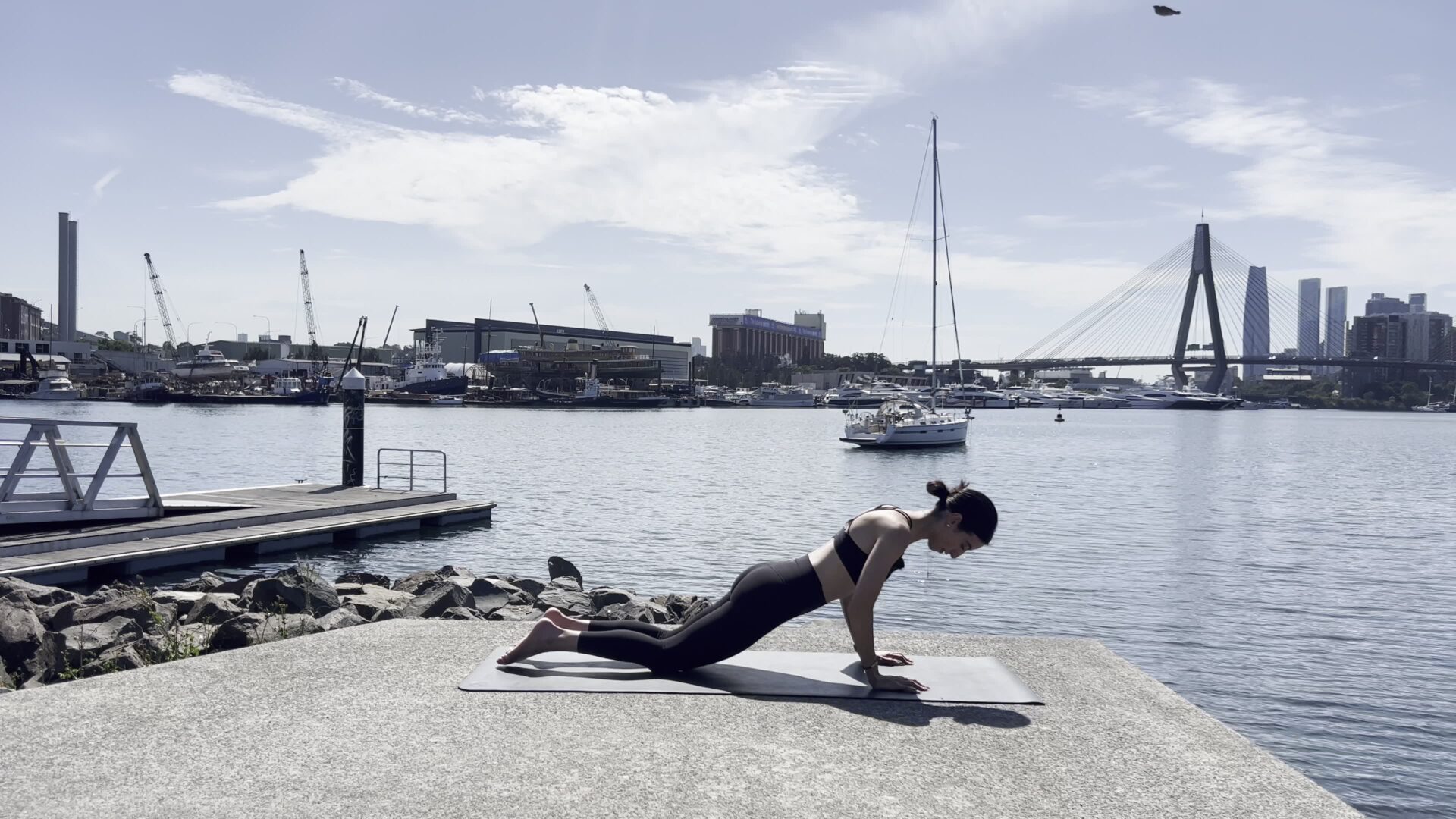 woman deciding between online pilates vs studio pilates practising on a yoga mat at home