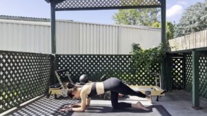 Woman doing Pilates core exercises for a flat stomach at home on a yoga mat